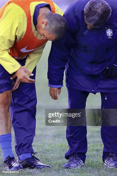 Brazilian Under-20 soccer player, Edu Dracena , shows his right knee to the team's doctor, 19 June 2001, during practice in Cordoba, Argentina. El...