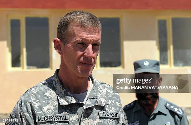 Commander of the NATO-led International Security Assistance Force US General Stanley McChrystal is watched by an Afghan National Police officer as he...