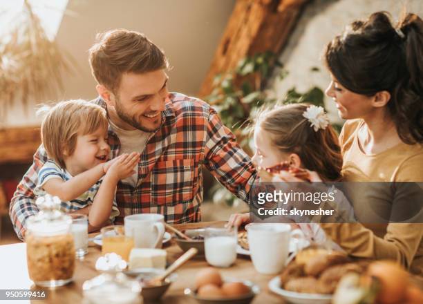 jovem família feliz comunicando-se ao ter o pequeno-almoço na sala de jantar. - café da manhã - fotografias e filmes do acervo