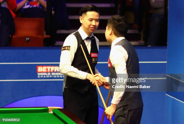 Xiao Guodong of China shakes hands with Ding Junhui of China after losing his first round match during day four of the World Snooker Championship at...