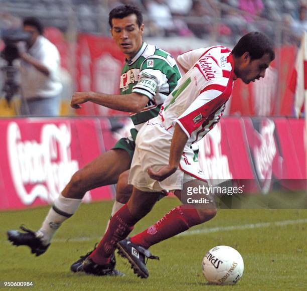Jared Borgetti of the Santos Laguna team fights Salvador Cabrera of Necaxa for the ball, 17 February 2002, in the Azteca stadium in Mexico City....