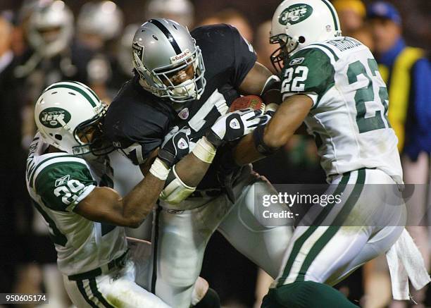 Oakland Raiders' runningback Tyrone Wheatley is tackled by New York Jets' free-safety Damien Robinson and Jets' cornerback Donnie Abraham during the...