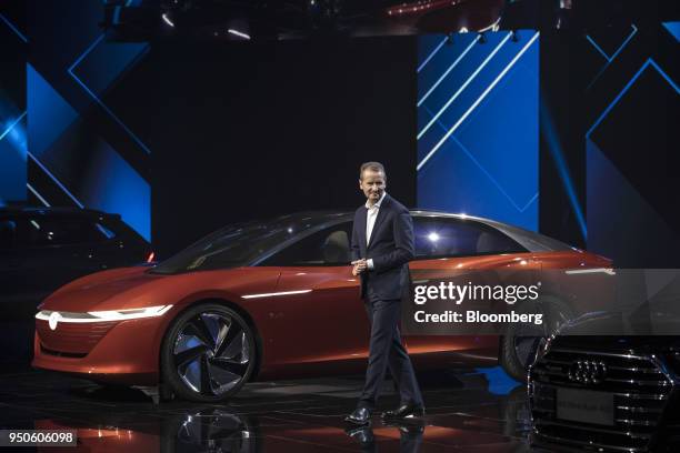 Herbert Diess, chief executive officer of Volkswagen AG , walks past an electric I.D. Vizzion concept-model limousine, left, at a media event ahead...