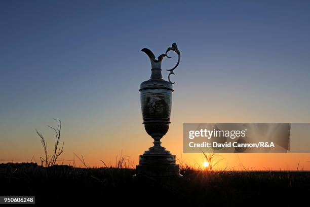 The Claret Jug, the Open Championship trophy as the sun rises beside the sixth green during the media day for the 147th Open Championship on the...