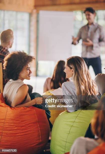 happy creative coworkers talking during a business presentation at casual office. - training bean bag stock pictures, royalty-free photos & images