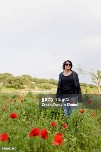 young woman  standing in field of red poppies, selective focus - stehmohn stock-fotos und bilder