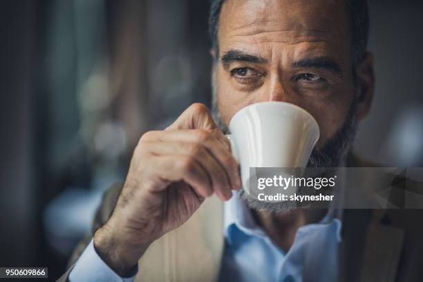 porträt eines bärtigen senior kaffee in einem café zu trinken. - espresso trinken stock-fotos und bilder