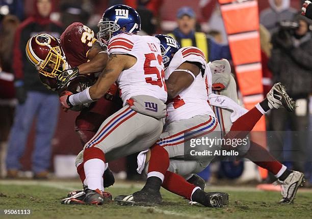 Marcus Mason of the Washington Redskins is tackled by Michael Boley of the New York Giants during their game on December 21, 2009 at Fedex Field in...