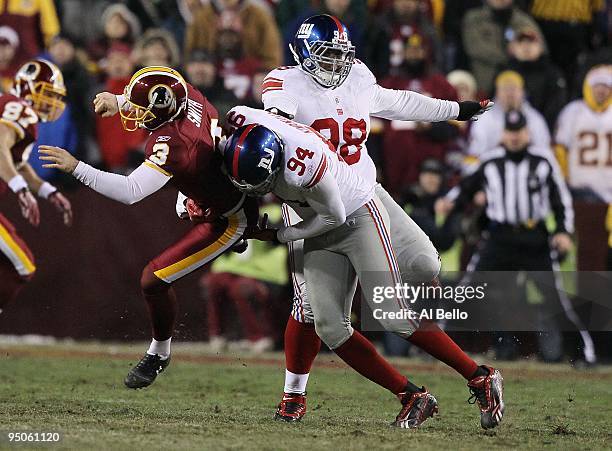 Hunter Smith of the Washington Redskins is tackled by Mathias Kiwanuka of the New York Giants on a fake field goal during their game on December 21,...