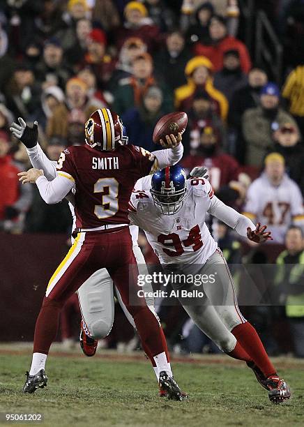 Hunter Smith of the Washington Redskins is tackled by Mathias Kiwanuka of the New York Giants on a fake field goal during their game on December 21,...