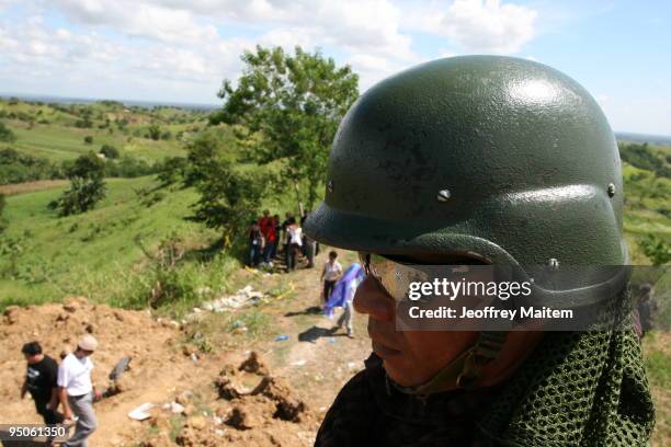 Filipino soldier secures the area after journalists offered flowers, prayers and lit candles at the site where 57 people, including many journalists,...