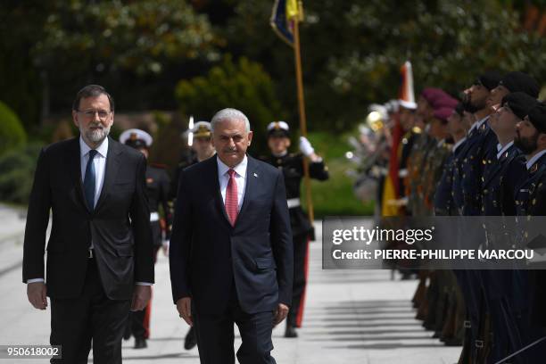 Spain's Prime Minister Mariano Rajoy reviews the honor guard with Turkish Prime Minister Binali Yildirim at La Moncloa palace in Madrid on April 24,...