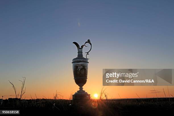 The Claret Jug, the Open Championship trophy as the sun rises beside the sixth green during the media day for the 147th Open Championship on the...
