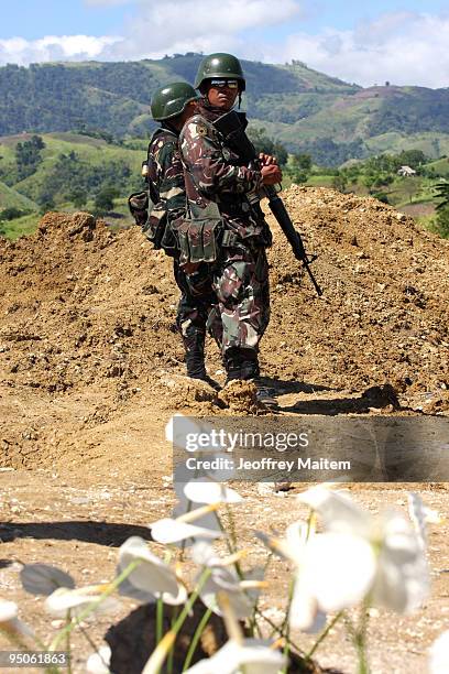 Filipino soldiers secure the area after journalists offered flowers, prayers and lit candles at the site where 57 people, including many journalists,...