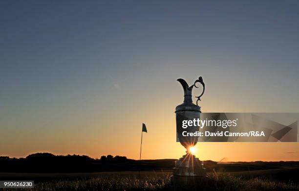 The Claret Jug, the Open Championship trophy as the sun rises beside the sixth green during the media day for the 147th Open Championship on the...