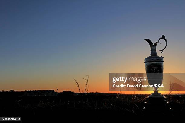 The Claret Jug, the Open Championship trophy as the sun rises beside the sixth green during the media day for the 147th Open Championship on the...