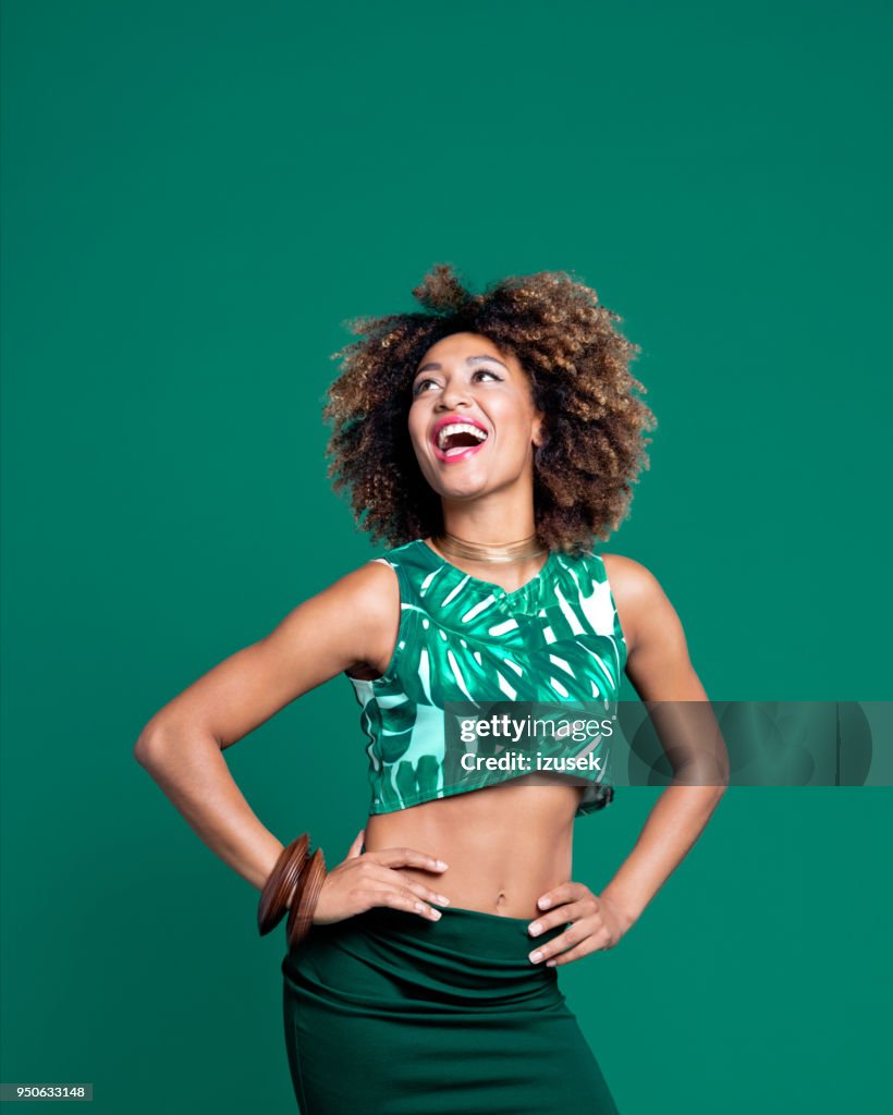 Retrato de verano de mujer joven afro excitada sobre fondo verde