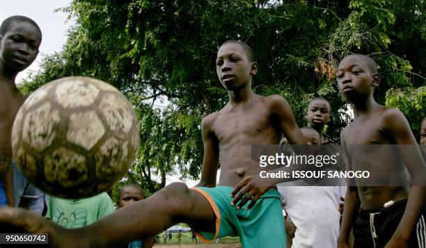 Ivorian boys play street soccer 16 May 2006 in a poor neighbourhood of Abidjan. Thousands of young football players are conned each year by...