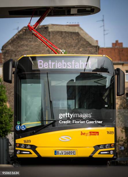 An electric bus is pictured during the charge process on April 24, 2018 in Berlin, Deutschland.