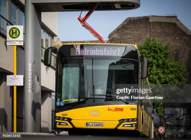 An electric bus is pictured during the charge process on April 24, 2018 in Berlin, Deutschland.