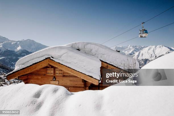 a snow covered ski chalet on a bright sunny winters day in verbier, switzerland - verbier ストックフォトと画像