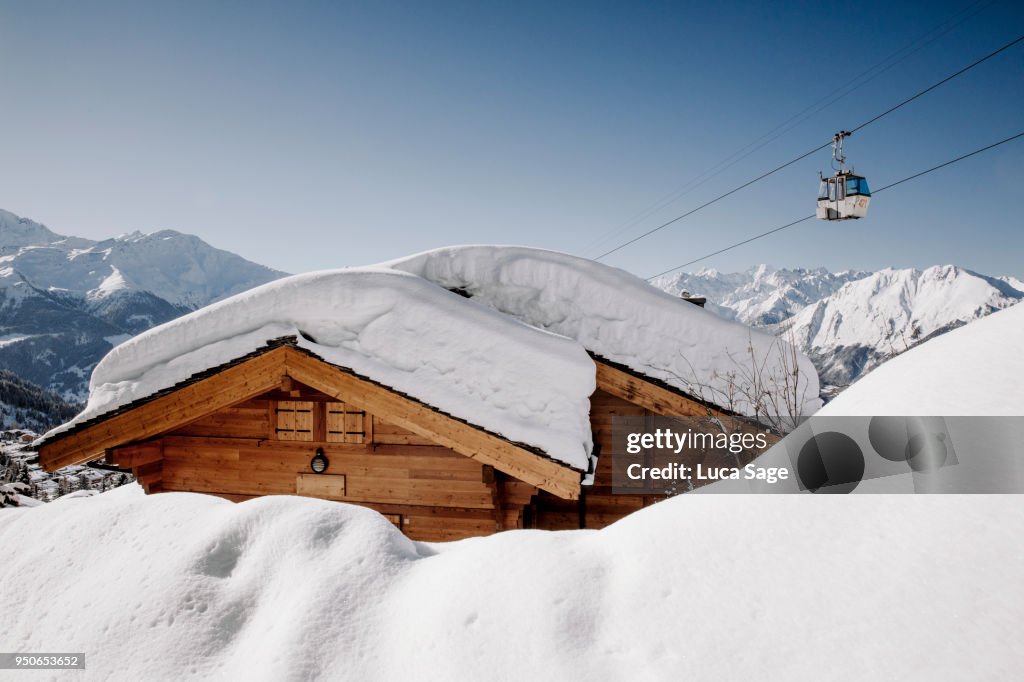 A snow covered ski chalet on a bright sunny winters day in Verbier, Switzerland