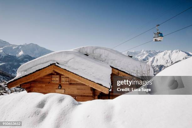 a snow covered ski chalet on a bright sunny winters day in verbier, switzerland - verbier stock pictures, royalty-free photos & images