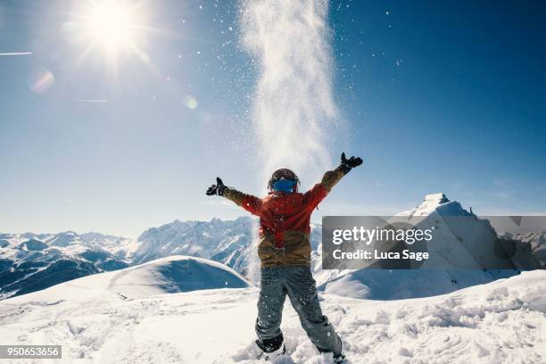 young boy enjoying sun and snow fun on top of a mountain - verbier ストックフォトと画像