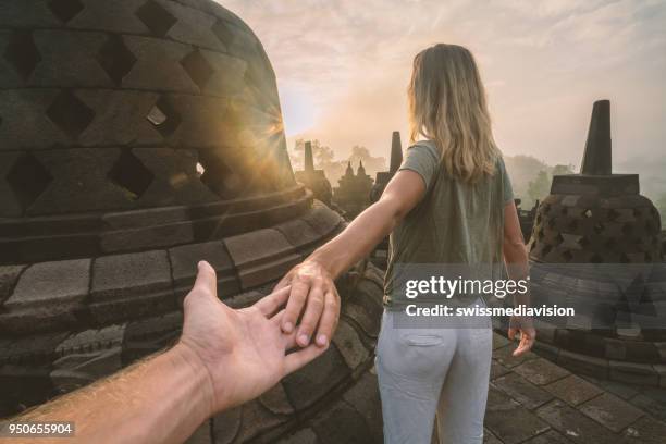 follow me to concept, woman leading boyfriend to borobudur temple at sunrise, indonesia - borobudur temple stock pictures, royalty-free photos & images