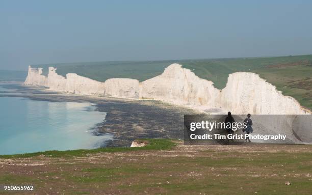 young couple viewing the seven sisters cliffs - seven sisters klif stockfoto's en -beelden