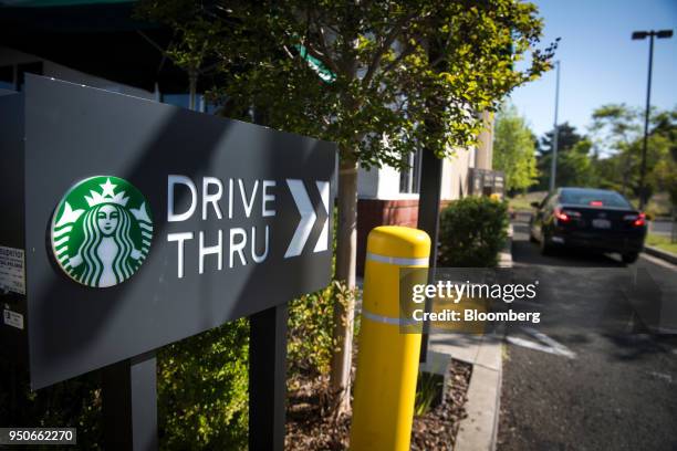 The Starbucks Corp. Logo is displayed on a "Drive Thru" sign outside a coffee shop location in Rodeo, California, U.S., on Monday, April 23, 2018....