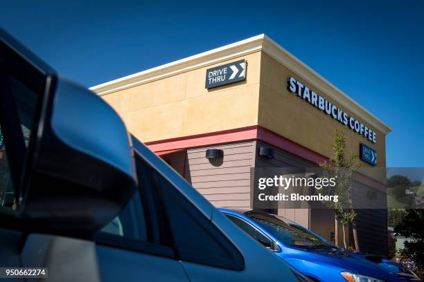 Starbucks Corp. Signage is displayed next to a "Drive Thru" sign at a coffee shop location in Pinole, California, U.S., on Monday, April 23, 2018....