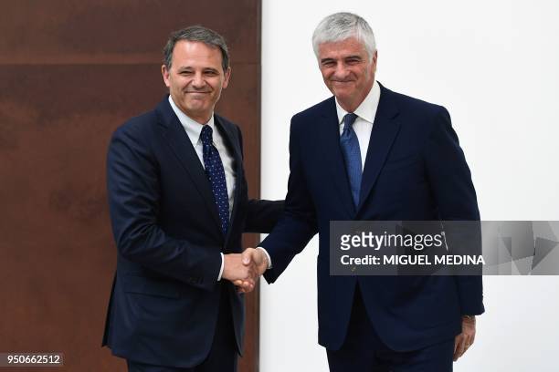 Deputy General Director of the LVMH group Antonio Belloni shakes hands with CEO of Thelios industry Giovanni Zoppas during the inauguration of the...