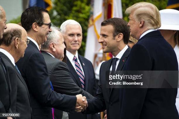 Emmanuel Macron, France's president, second right, greets Steven Mnuchin, U.S. Treasury secretary, beside U.S. President Donald Trump, right, at an...