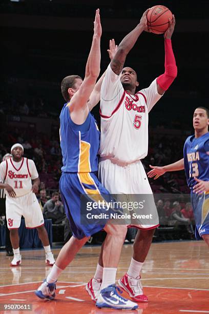 Sean Evans of St. John's Red Storm attempts a shot against Miklos Szabo of Hofstra Pride at Madison Square Garden on December 20, 2009 in New York,...