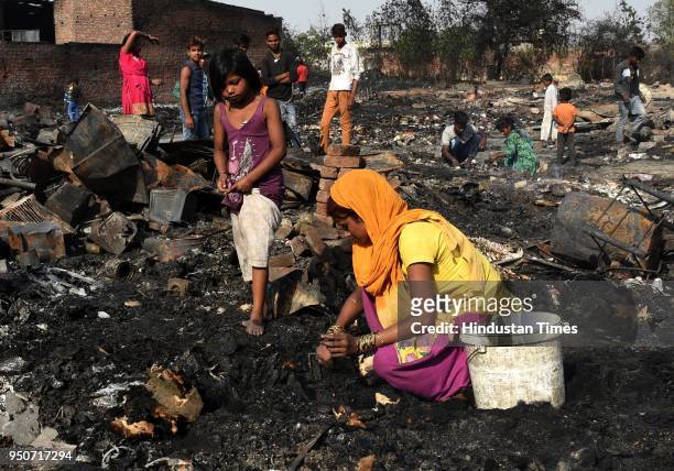 Residents rummage through debris after their houses were gutted in a fire at a slum in Shahbad Dairy near Rohini, on April 24, 2018 in New Delhi,...