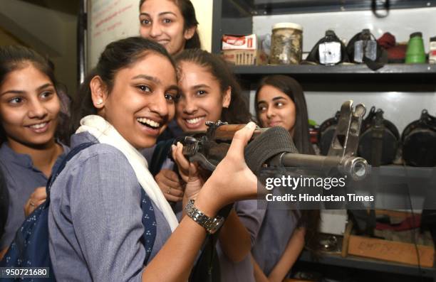 Modern School students look at a gun during their visit at Barakhamba Road Police station to have first-hand knowledge of medico legal and...