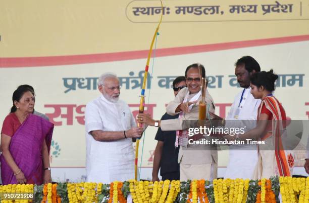 Madhya Pradesh Chief Minisiter Shivraj Singh Chouhan presents a bow and arrow to Prime Minister Narendra Modi during the occasion of National...