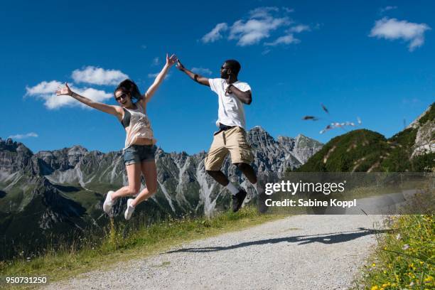 couple jumping joyfully in the air, hike, kalkkoegel behind, fulpmes, stubai valley, tyrol, austria - howse peak 個照片及圖片檔