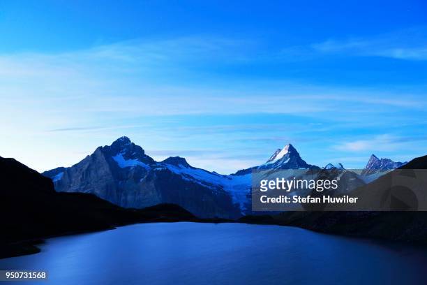 early morning at bachalpsee lake, wetterhorn, schreckhorn, finsteraarhorn and first, grindelwald, canton of bern, switzerland - wetterhorn stock pictures, royalty-free photos & images