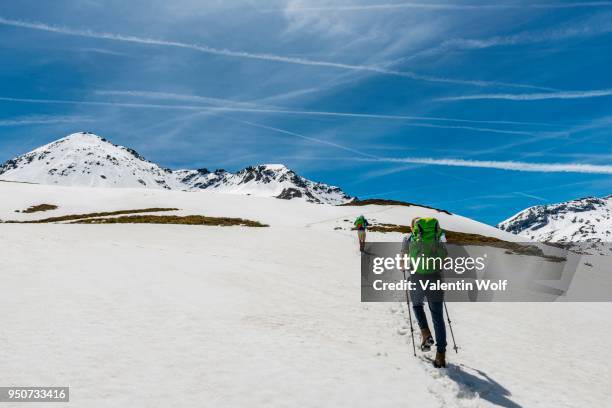 two hikers walk over snowfield, rohrmoos-untertal, schladming tauern, schladming, styria, austria - howse peak stock-fotos und bilder