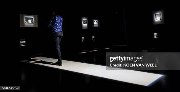 Woman looks at artworks by Dutch artist MC Escher during a preview of the exhibition "Escher on Journey" at the Fries Museum in Leeuwarden on April...