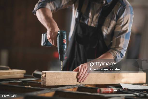 giovane falegname che lavora nel suo laboratorio - drill foto e immagini stock