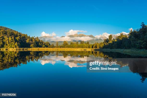 scenic view of mountain range reflected in lake matheson, south island, new zealand - south westland stock-fotos und bilder