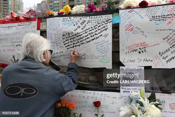 Jack Young leaves a notes on April 24 at a makeshift memorial for victims in the van attack in Toronto, Ontario. - A van driver who ran over 10...