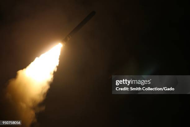 The guided-missile destroyer USS Laboon fires a Tomahawk land attack missile at a target in Syria from the US 5th Fleet Area of Responsibility, April...