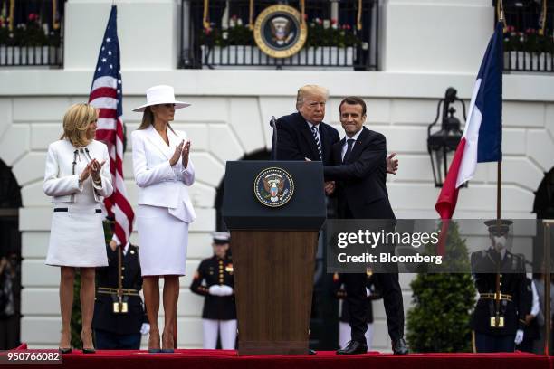 President Donald Trump, center, hugs Emmanuel Macron, France's president, right, while Brigitte Macron, France's first lady, from left, and U.S....