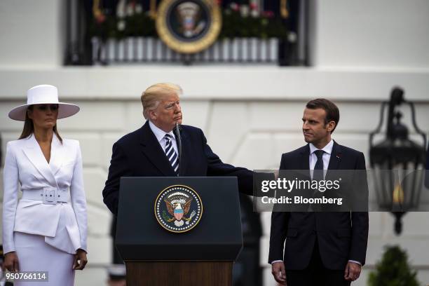President Donald Trump, center, speaks while Emmanuel Macron, France's president, right, and U.S. First Lady Melania Trump listen at an arrival...