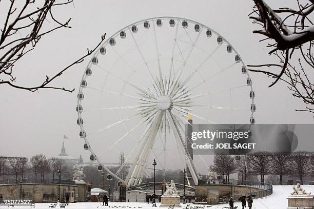 View taken from the Tuileries gardens under snow showing the Ferry wheel place de la Concorde in Paris on December 17, 2009. Snow hit today the Paris...