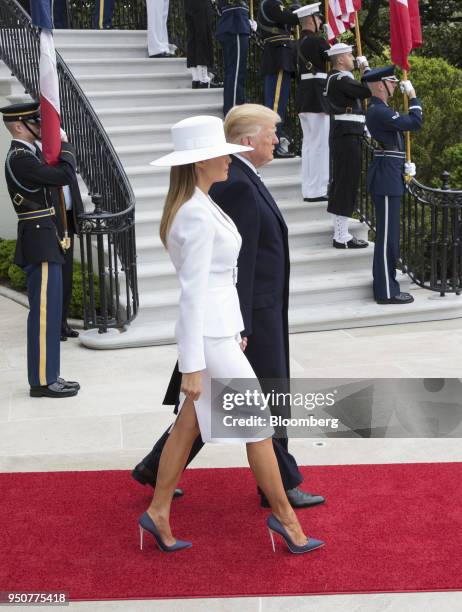 President Donald Trump, left, and U.S. First Lady Melania Trump walk out of the White House to greet Emmanuel Macron, France's president, and...